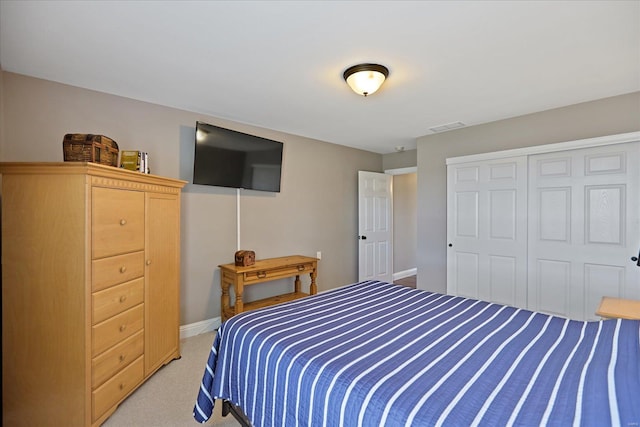 bedroom with visible vents, baseboards, light colored carpet, and a closet