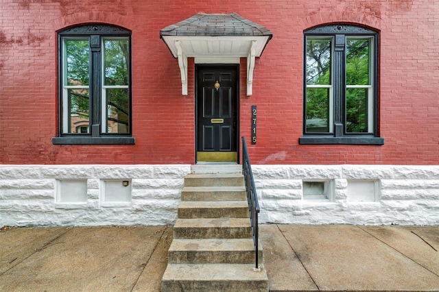 doorway to property featuring brick siding