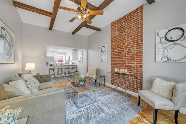 living room with beamed ceiling, baseboards, a ceiling fan, and a fireplace