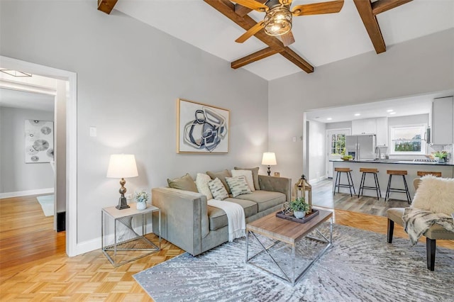 living room with baseboards, recessed lighting, ceiling fan, parquet flooring, and beamed ceiling