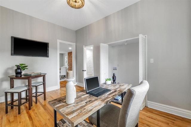 office area featuring baseboards and light wood finished floors