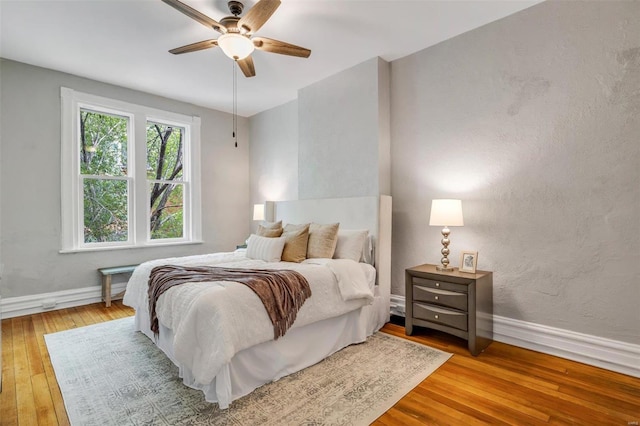 bedroom with baseboards, ceiling fan, and light wood finished floors