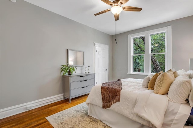 bedroom featuring light wood-style flooring, baseboards, and ceiling fan