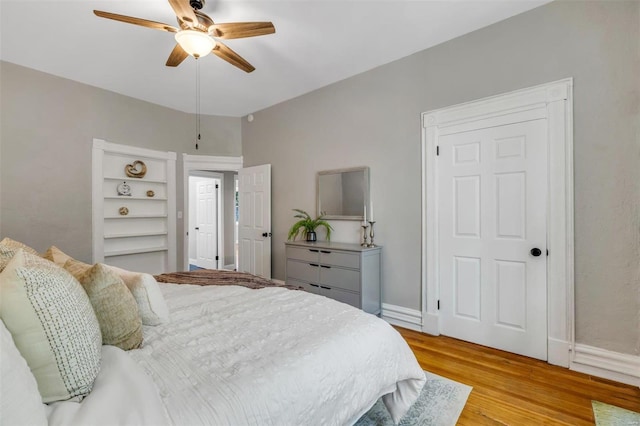 bedroom featuring ceiling fan, baseboards, and light wood-style flooring