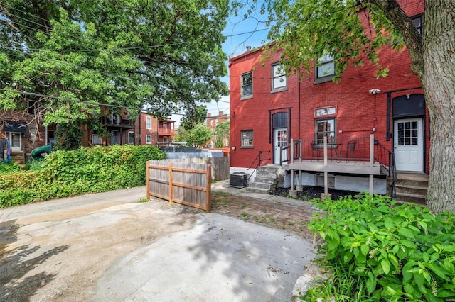 view of property featuring brick siding and fence