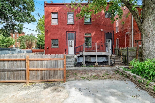 view of front of home featuring brick siding and a fenced front yard