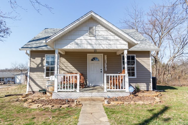 bungalow-style home featuring covered porch and roof with shingles