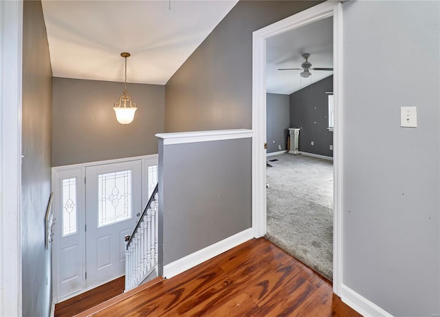 entryway with dark wood-style floors, dark carpet, lofted ceiling, and baseboards