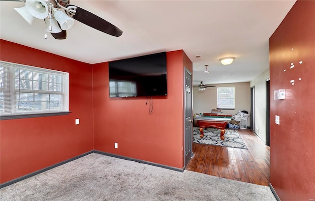 hall with visible vents, baseboards, wood finished floors, and carpet flooring