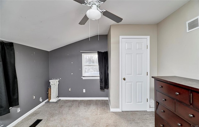 carpeted spare room with visible vents, a ceiling fan, baseboards, and vaulted ceiling