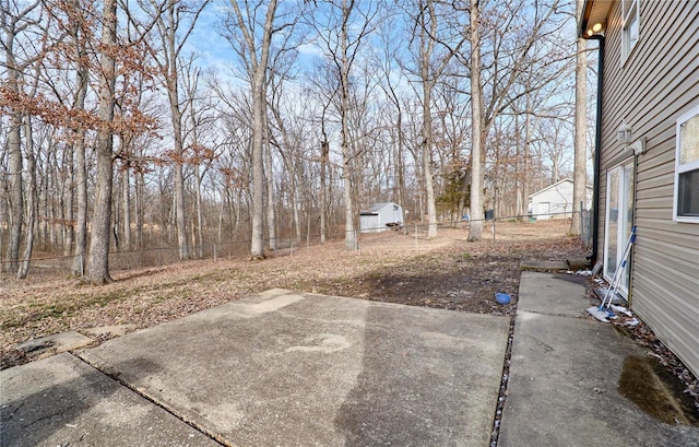 view of yard with a fenced backyard, a storage shed, an outbuilding, and a patio