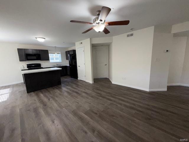 unfurnished living room with visible vents, ceiling fan, dark wood-type flooring, and baseboards