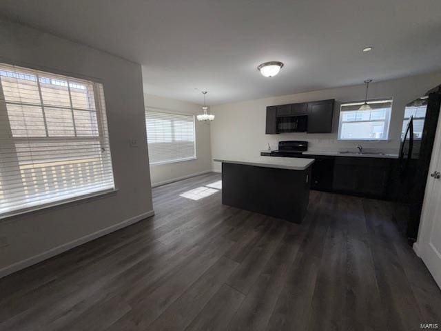 kitchen with a center island, plenty of natural light, black appliances, and light countertops