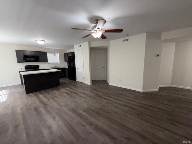 unfurnished living room with visible vents, baseboards, dark wood-style floors, and a ceiling fan