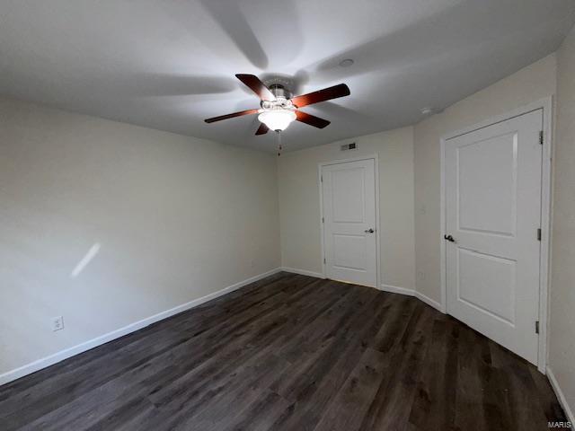 unfurnished bedroom with a ceiling fan, dark wood-style floors, and baseboards