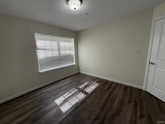 unfurnished room with baseboards and wood finished floors