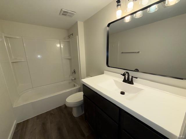 full bathroom featuring vanity, wood finished floors, visible vents, toilet, and shower / bathtub combination