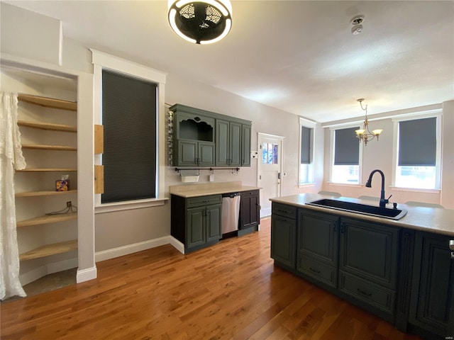 kitchen with a sink, open shelves, wood finished floors, light countertops, and dishwasher