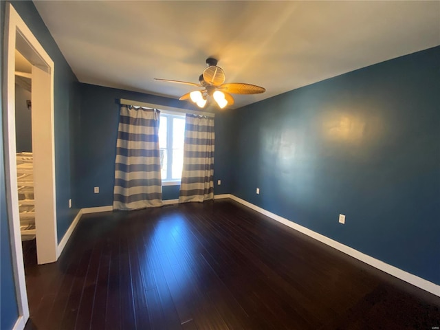 empty room featuring a ceiling fan, baseboards, and wood finished floors