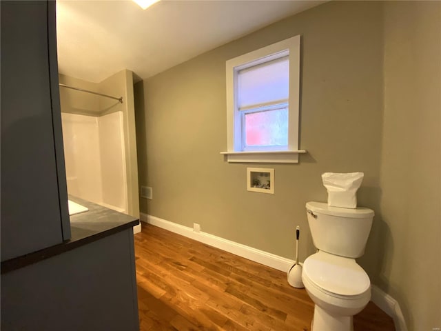 full bath with toilet, wood finished floors, baseboards, walk in shower, and vanity