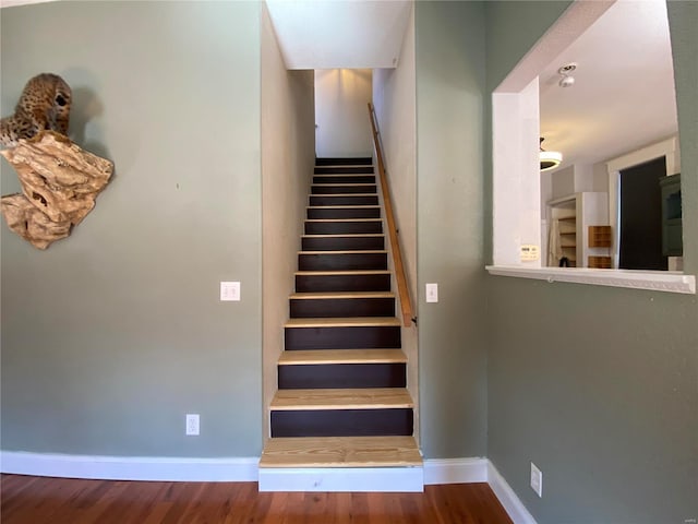 stairs featuring wood finished floors and baseboards