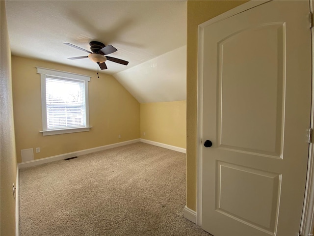 additional living space featuring baseboards, visible vents, carpet floors, and lofted ceiling