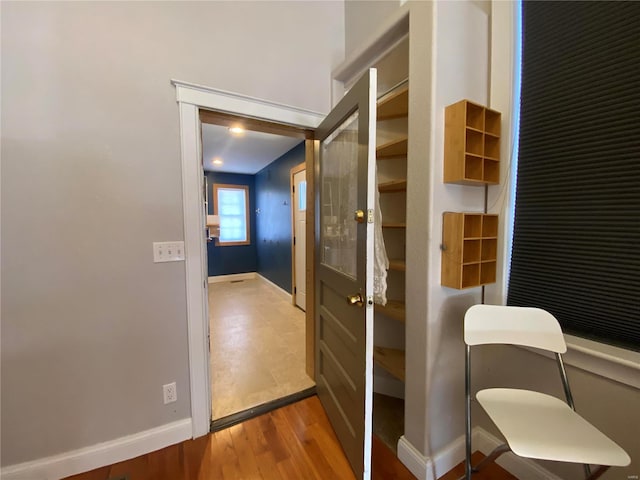 hall featuring baseboards and wood finished floors