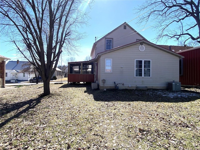 rear view of property featuring central AC and a sunroom