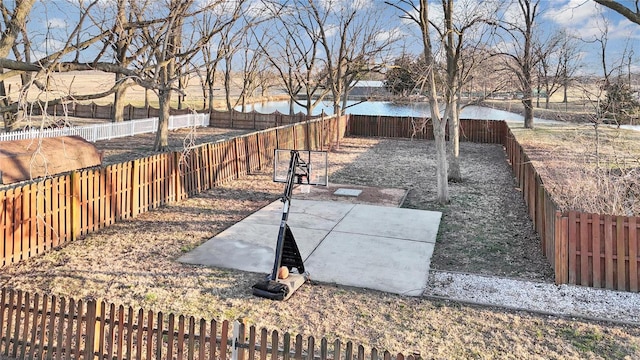 view of yard with a fenced backyard and a water view