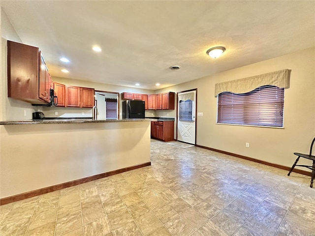 kitchen with dark countertops, baseboards, recessed lighting, a peninsula, and black appliances