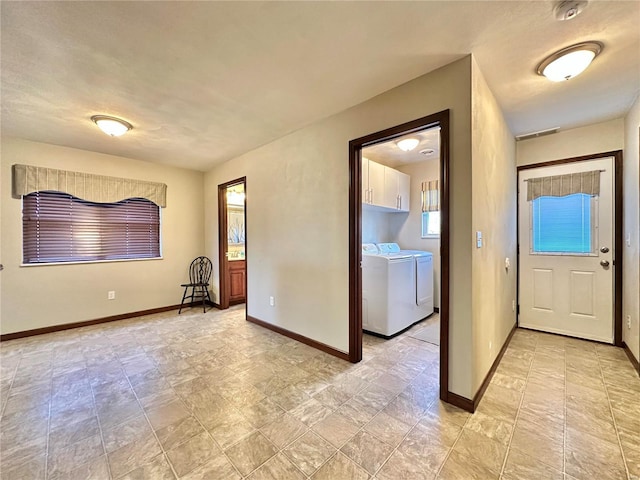 foyer entrance with washing machine and dryer and baseboards