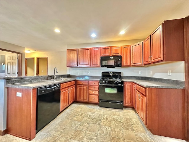 kitchen with dark countertops, recessed lighting, a peninsula, black appliances, and a sink