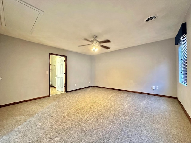 empty room featuring a ceiling fan, baseboards, visible vents, attic access, and light carpet