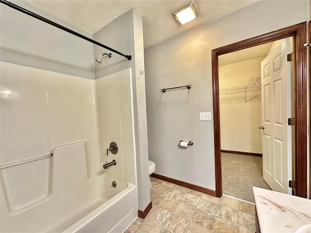 full bathroom featuring  shower combination, a spacious closet, toilet, and baseboards