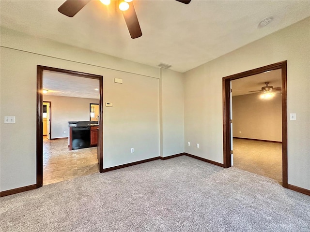 empty room featuring light colored carpet, visible vents, and baseboards