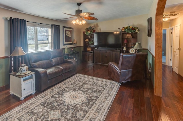 living room with dark wood-type flooring and a ceiling fan