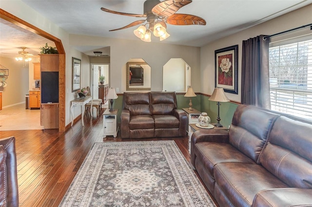 living area with baseboards, ceiling fan, and light wood finished floors