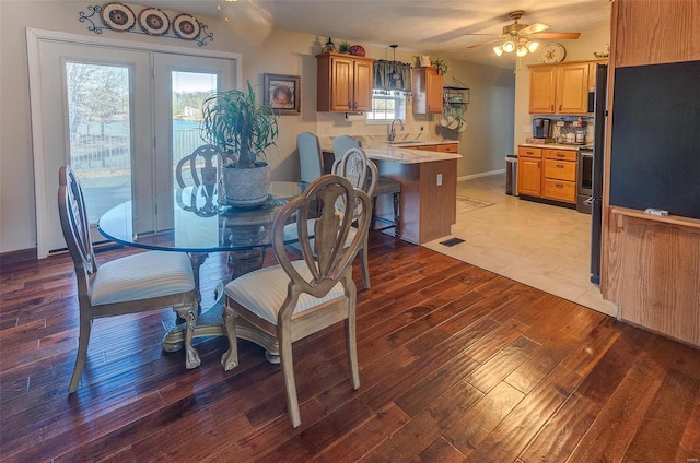 dining area featuring light wood-style flooring, a ceiling fan, and visible vents