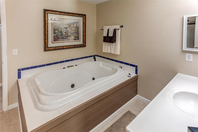 bathroom with baseboards, a jetted tub, vanity, and tile patterned flooring