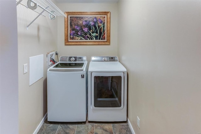 washroom featuring laundry area, washing machine and dryer, and baseboards