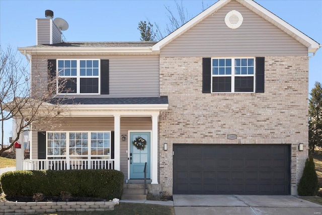 traditional home featuring brick siding, a porch, a chimney, and concrete driveway