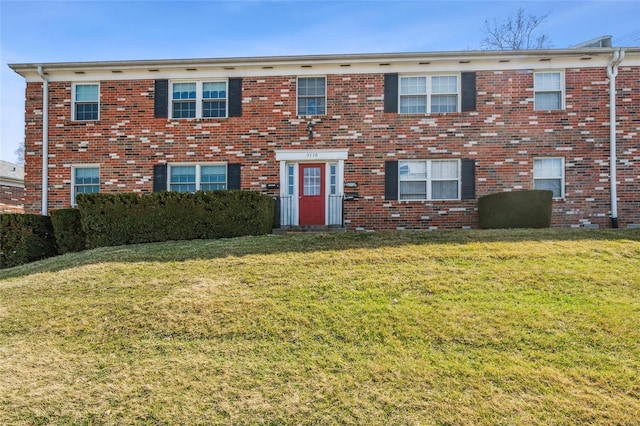 view of front facade featuring brick siding and a front lawn