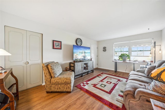 living area featuring light wood-style flooring and baseboards