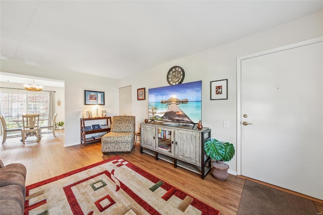 living room with baseboards, an inviting chandelier, and wood finished floors