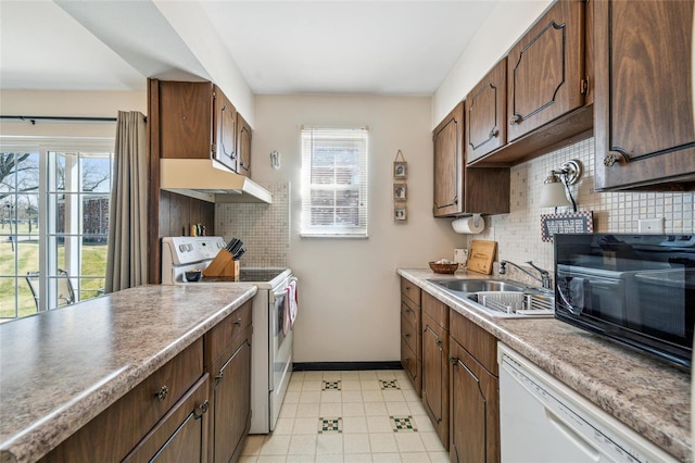 kitchen featuring a sink, white appliances, plenty of natural light, and under cabinet range hood