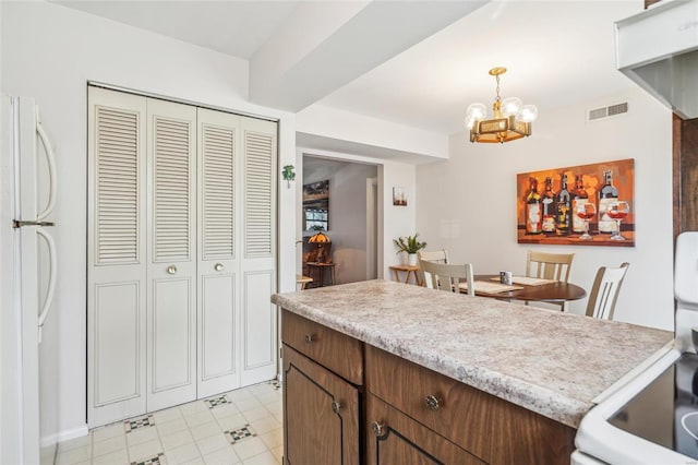 kitchen featuring visible vents, decorative light fixtures, white appliances, light countertops, and a chandelier