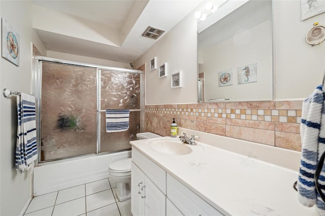 full bath featuring tile patterned floors, visible vents, tile walls, enclosed tub / shower combo, and vanity