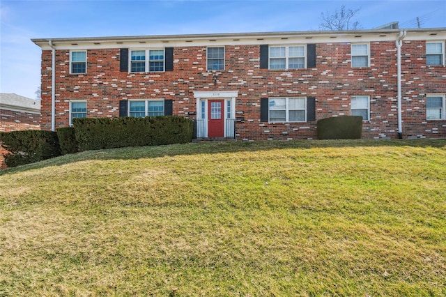 view of front of home with brick siding and a front lawn