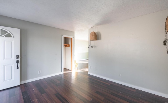 interior space featuring a textured ceiling, baseboards, and wood finished floors