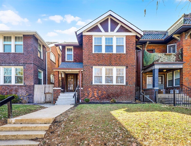 view of front of property featuring brick siding, a front yard, and fence